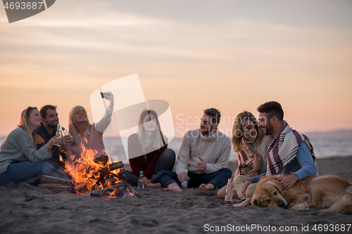 Image of Friends having fun at beach on autumn day