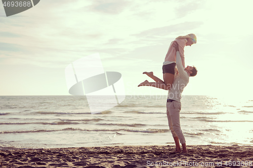 Image of Loving young couple on a beach at autumn sunny day