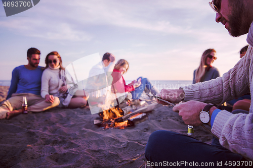 Image of Friends having fun at beach on autumn day