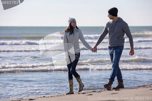 Image of Loving young couple on a beach at autumn sunny day