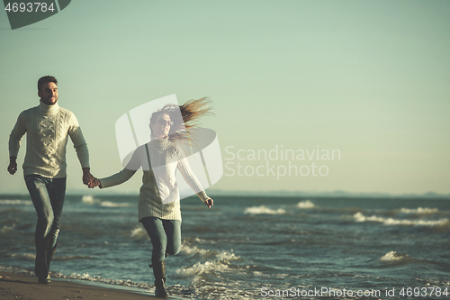 Image of Loving young couple on a beach at autumn sunny day