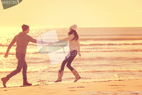 Image of Loving young couple on a beach at autumn sunny day