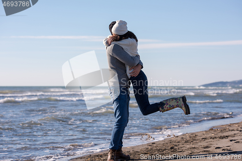 Image of Loving young couple on a beach at autumn sunny day