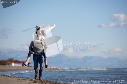 Image of couple having fun at beach during autumn