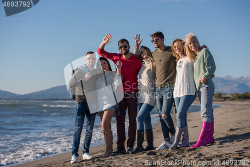 Image of portrait of friends having fun on beach during autumn day