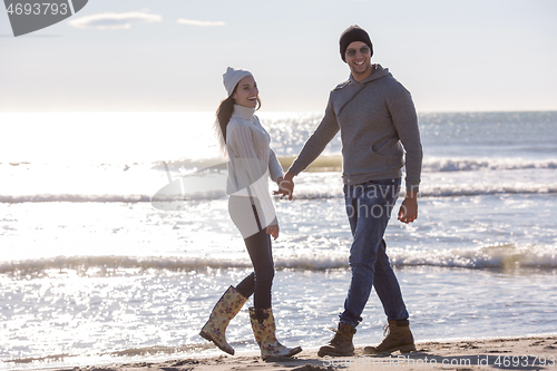 Image of Loving young couple on a beach at autumn sunny day