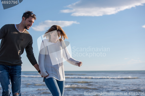 Image of Loving young couple on a beach at autumn sunny day