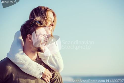 Image of couple having fun at beach during autumn