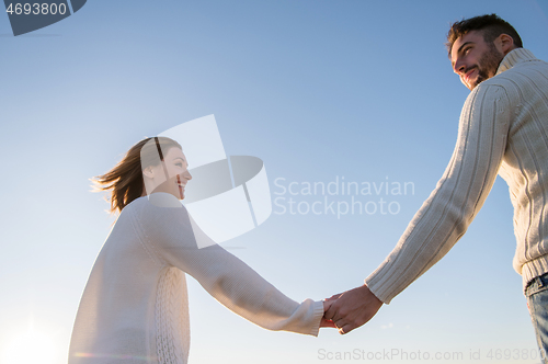 Image of Loving young couple on a beach at autumn sunny day