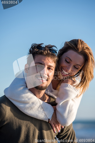 Image of couple having fun at beach during autumn