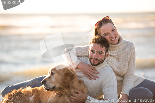 Image of Couple with dog enjoying time on beach