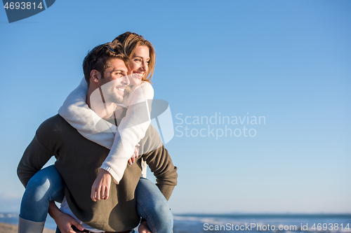 Image of couple having fun at beach during autumn