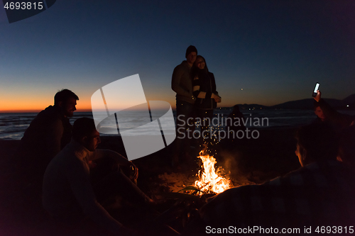 Image of Friends having fun at beach on autumn day