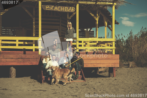 Image of Group of friends having fun on autumn day at beach