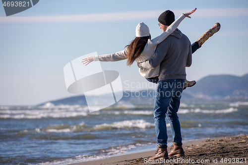 Image of Loving young couple on a beach at autumn sunny day