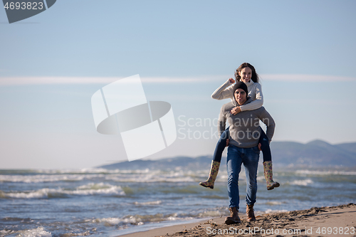 Image of couple having fun at beach during autumn