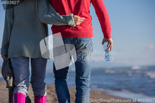 Image of Loving young couple on a beach at autumn sunny day