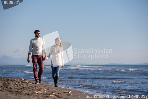 Image of Loving young couple on a beach at autumn sunny day