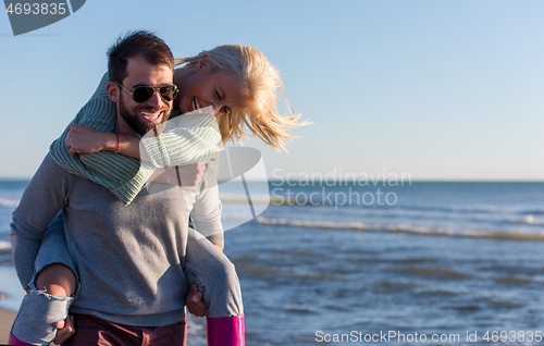 Image of couple having fun at beach during autumn