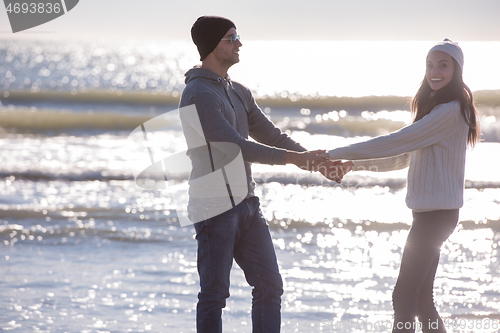 Image of Loving young couple on a beach at autumn sunny day