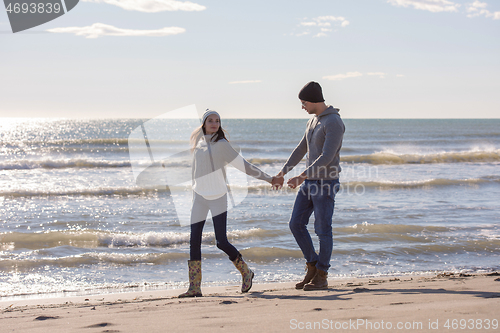 Image of Loving young couple on a beach at autumn sunny day