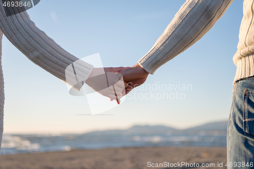 Image of Loving young couple on a beach at autumn sunny day