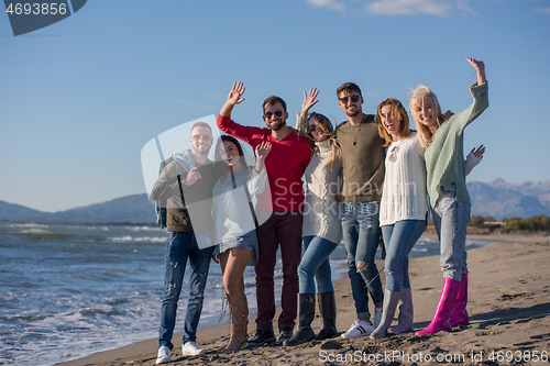 Image of portrait of friends having fun on beach during autumn day