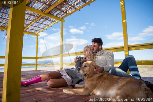 Image of Couple with dog enjoying time on beach