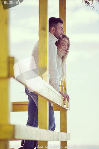 Image of young couple drinking beer together at the beach