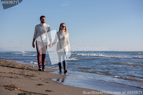 Image of Loving young couple on a beach at autumn sunny day