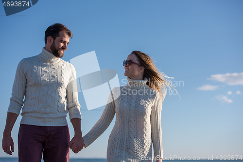 Image of Loving young couple on a beach at autumn sunny day