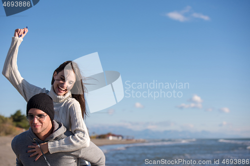 Image of couple having fun at beach during autumn