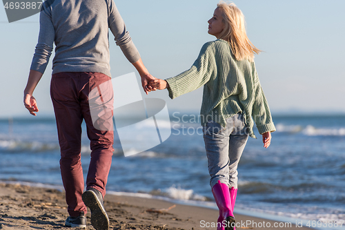 Image of Loving young couple on a beach at autumn sunny day