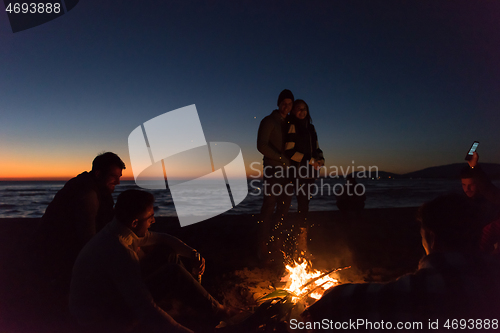 Image of Friends having fun at beach on autumn day