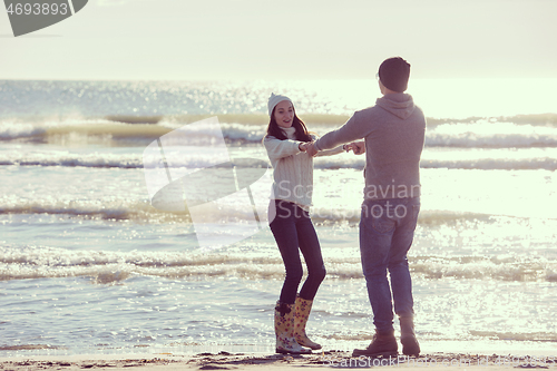 Image of Loving young couple on a beach at autumn sunny day