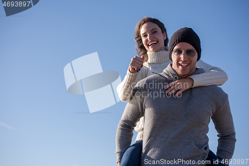 Image of couple having fun at beach during autumn