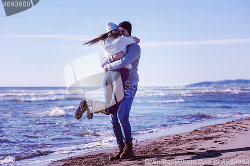 Image of Loving young couple on a beach at autumn sunny day