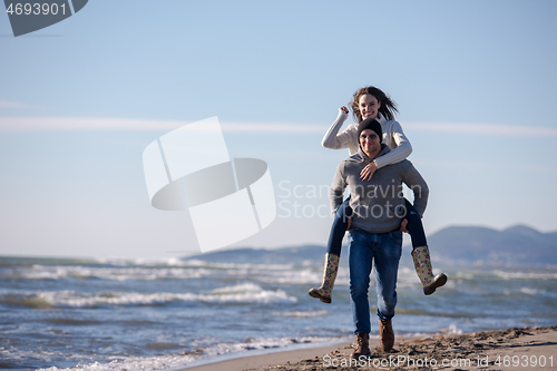 Image of couple having fun at beach during autumn