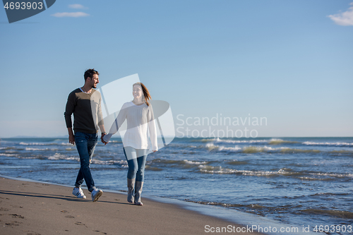 Image of Loving young couple on a beach at autumn sunny day