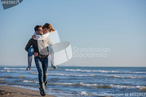 Image of couple having fun at beach during autumn