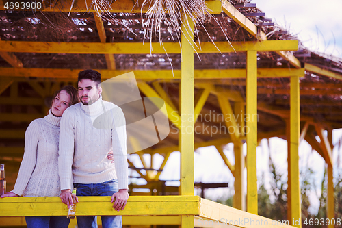 Image of young couple drinking beer together at the beach