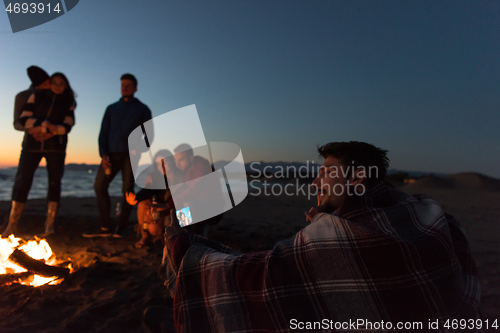 Image of Friends having fun at beach on autumn day