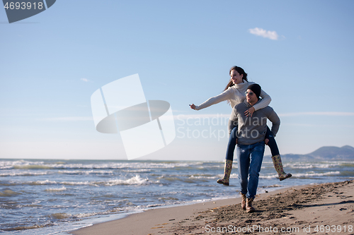 Image of couple having fun at beach during autumn