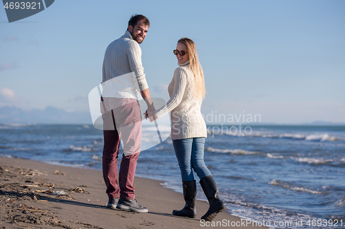 Image of Loving young couple on a beach at autumn sunny day