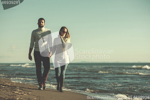 Image of Loving young couple on a beach at autumn sunny day