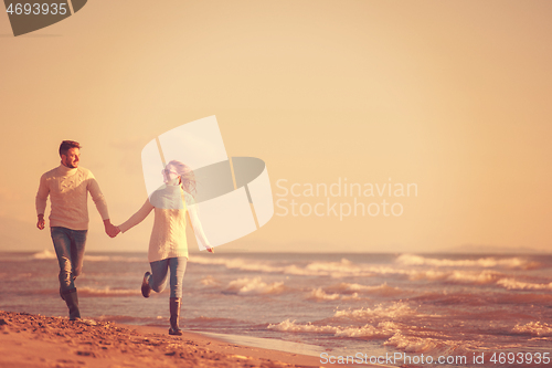 Image of Loving young couple on a beach at autumn sunny day