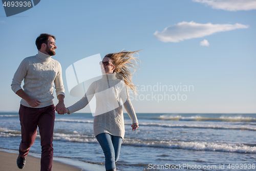 Image of Loving young couple on a beach at autumn sunny day