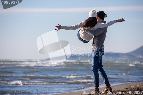 Image of Loving young couple on a beach at autumn sunny day