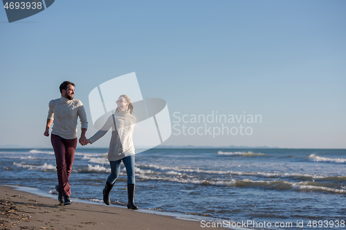 Image of Loving young couple on a beach at autumn sunny day