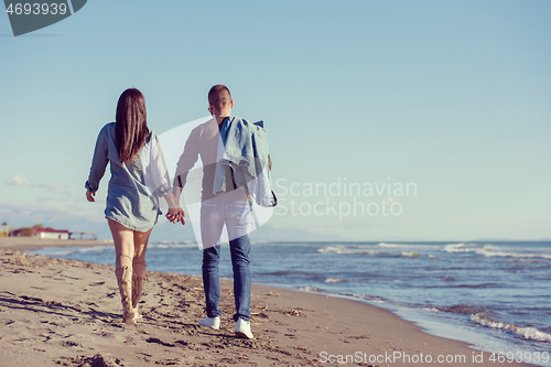 Image of Loving young couple on a beach at autumn sunny day